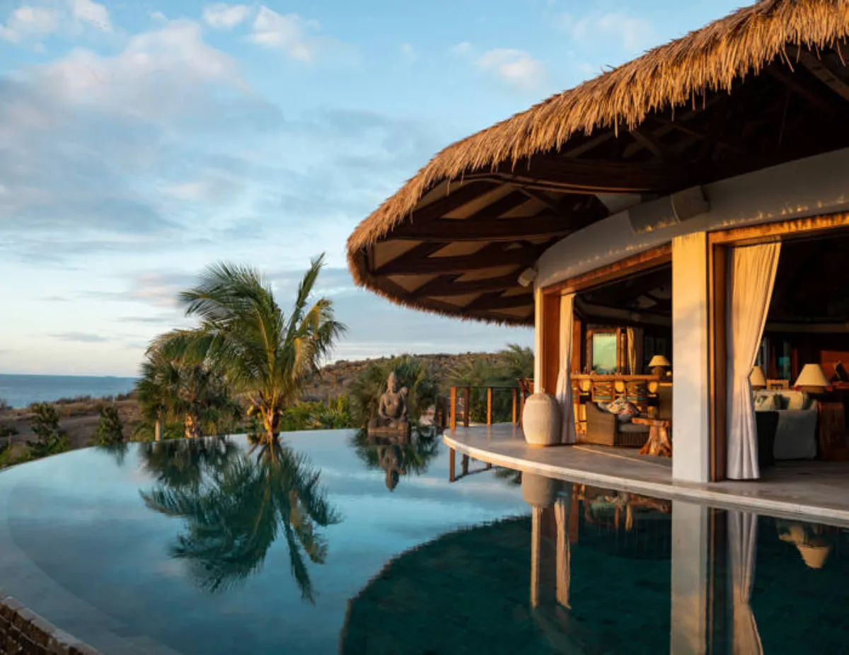 Luxury resort villa with dug-out swimming pool overlooking tropical beach, perfect for vacation relaxation