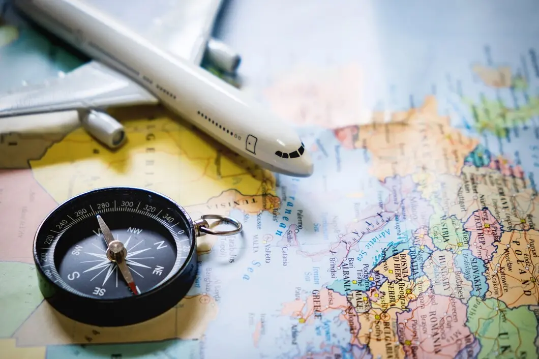 Close-up of a compass on a map showcasing geographical details for navigation and travel purposes