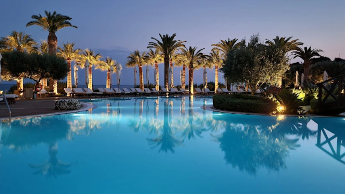 Luxury resort with palm-fringed dug-out swimming pool, beachfront view and hotel, ideal for tropical vacations.