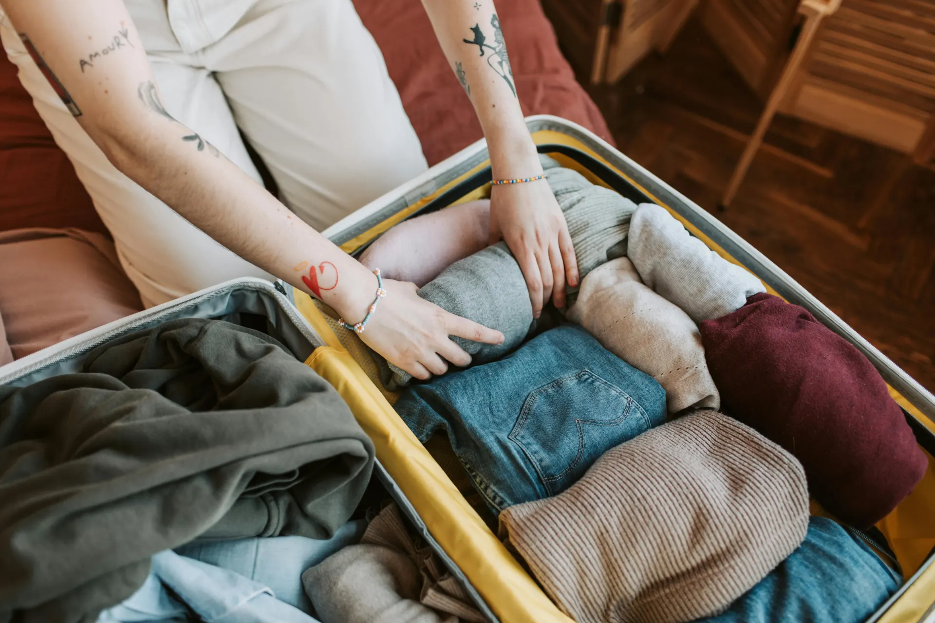 a person id packing a bag with clothes
