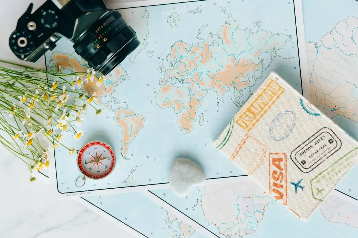 Paper map on a business-oriented desktop, adorned with a spherical travel globe, money and retro tech