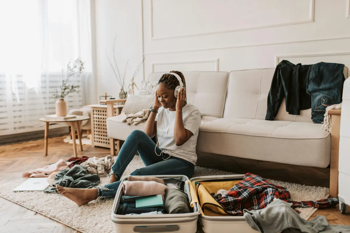 a girl is listening music with packing the bag