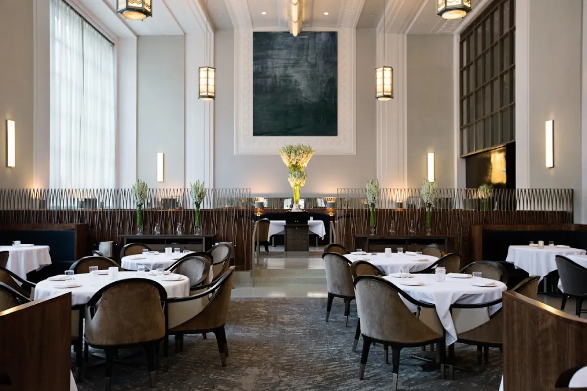 Luxurious contemporary interior featuring an elegant dining table set and chandelier within a room.
