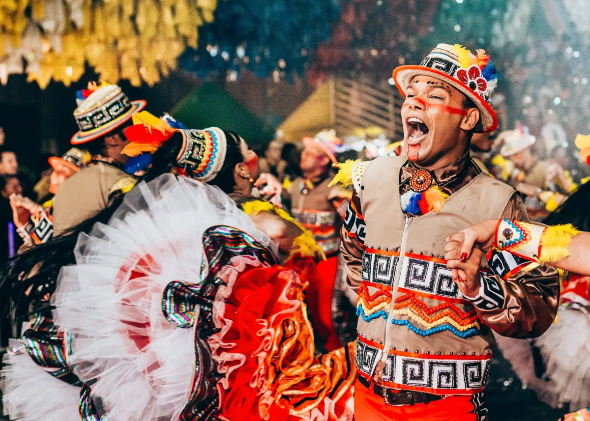Man in traditional costume and mask dancing at music festival during street parade celebration