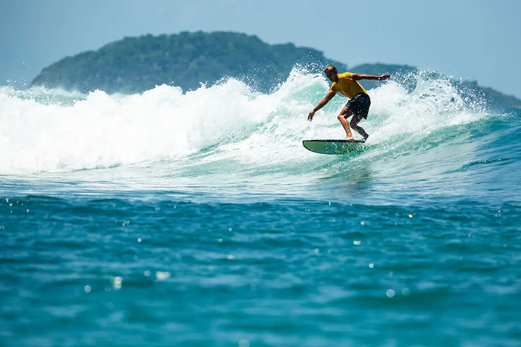 Surfer riding a huge wave during a sunny summer day, showcasing action energy and adventure