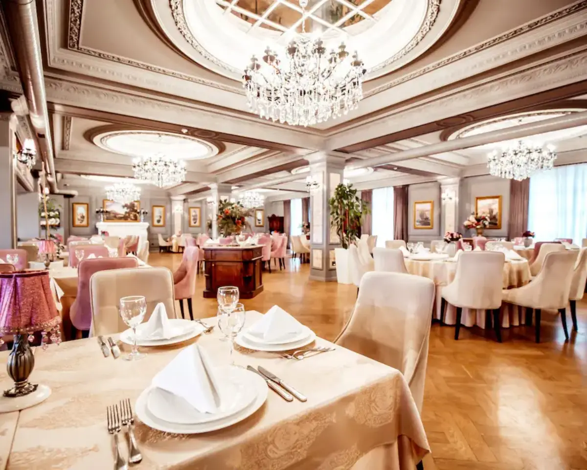 Elegant restaurant interior with crystal chandeliers, plush seating, and beautifully arranged tables set for fine dining.