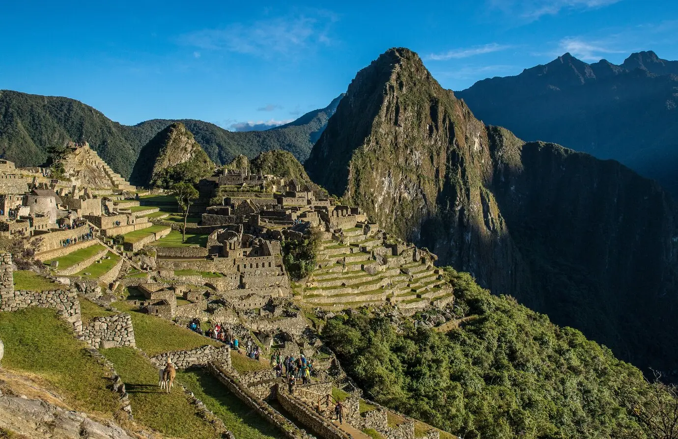 An ancient Incan hillside monastery amidst a scenic valley, under summer daylight